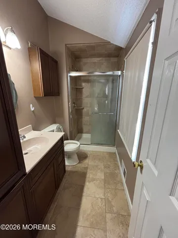 a bathroom with a granite countertop sink toilet and shower