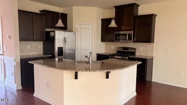 a kitchen with stainless steel appliances granite countertop a sink and a refrigerator