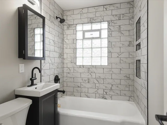 a bathroom with a sink a toilet and shower