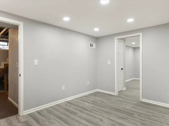 wooden floor in an empty room with wooden floor and a bathroom