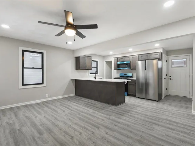 a view of kitchen with stainless steel appliances granite countertop refrigerator oven a sink dishwasher and a refrigerator with wooden floor