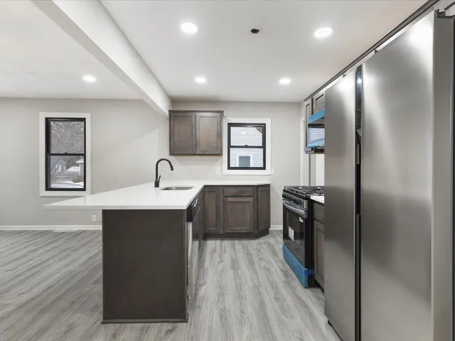 a kitchen with stainless steel appliances a sink stove and refrigerator