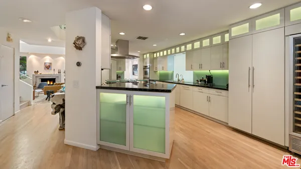 a kitchen with kitchen island granite countertop a refrigerator and a sink