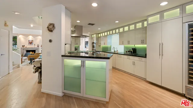 a kitchen with kitchen island granite countertop a refrigerator and a sink