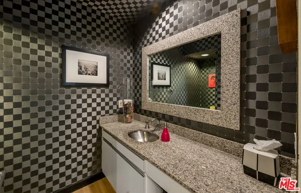 a bathroom with a granite countertop sink and a mirror