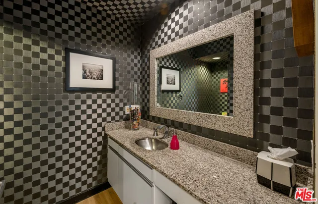 a bathroom with a granite countertop sink and a mirror