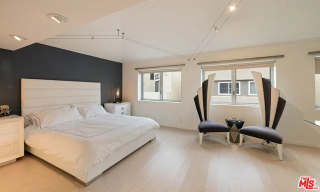 a bedroom with a large bed a desk and chair