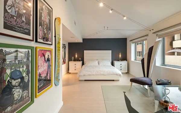 a bedroom with furniture and a painting on the wall