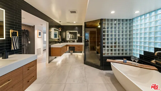 a large bathroom with a large tub a sink a double vanity and a shower