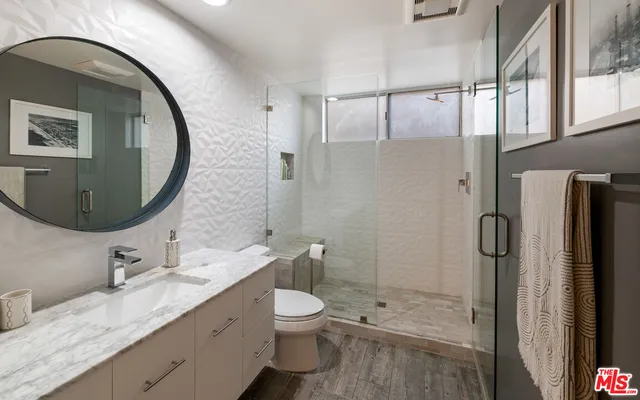 a bathroom with a granite countertop sink toilet and shower