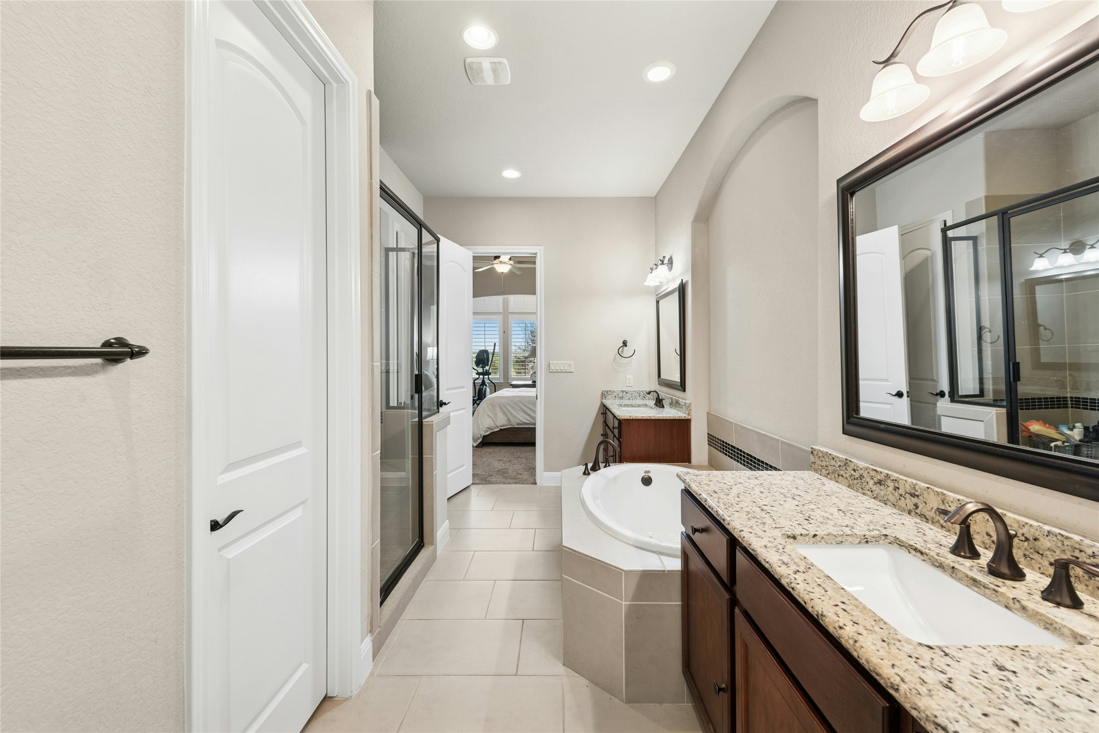 116 Evolutions Path Lakeway, TX 78738 - Photo 19 of 34 Full bathroom featuring connected bathroom, two vanities, a garden tub, light tile patterned floors, and a shower stall