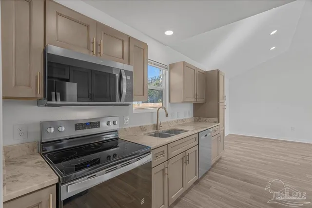 a kitchen with cabinets and steel appliances