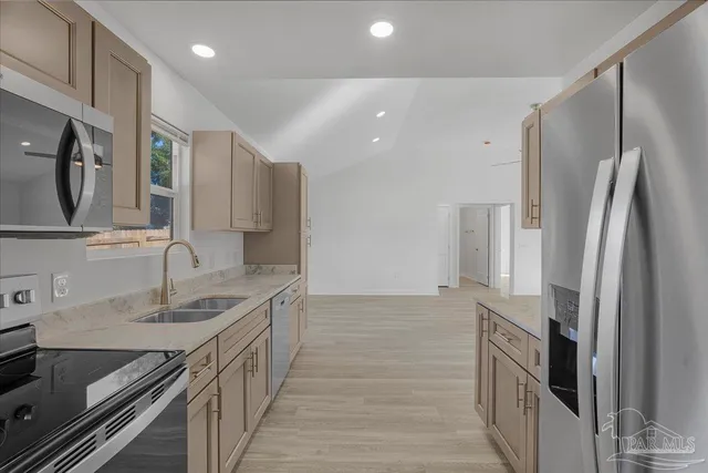a kitchen with stainless steel appliances granite countertop a refrigerator and a sink