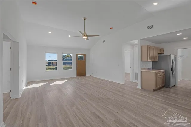 a view of empty room with kitchen appliances and wooden floor