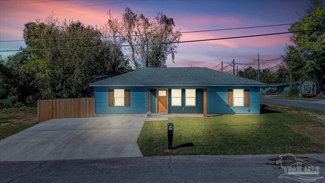a front view of a house with a yard and trees