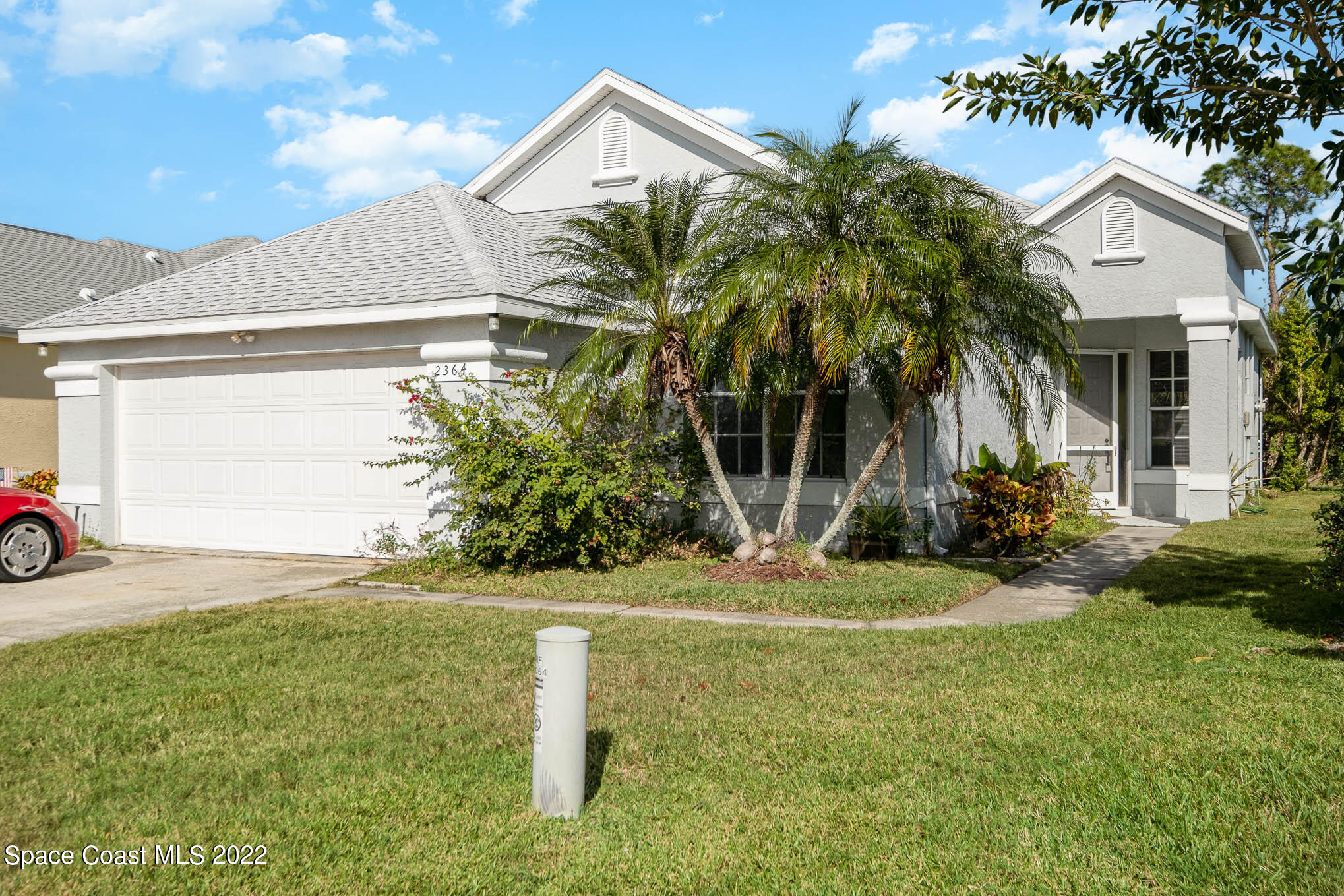 a view of a house with a yard and a garage