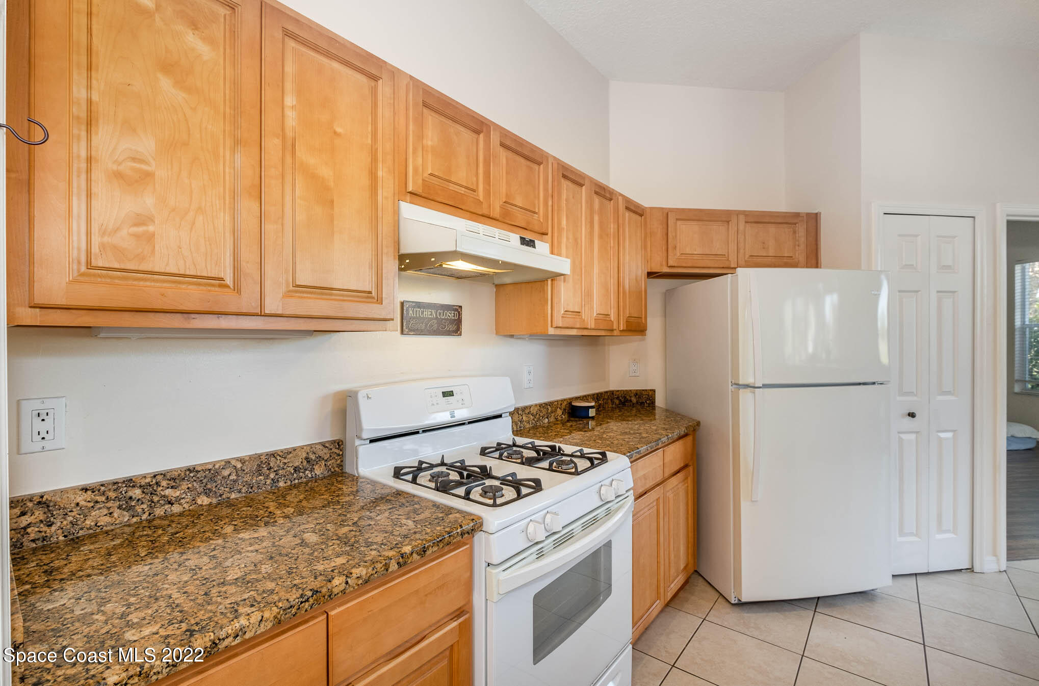 2364 Addington Circle Rockledge, FL 32955 - Photo 3 of 22 a kitchen with a stove a refrigerator and a white cabinets