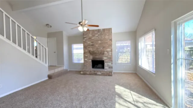 a view of an empty room with a fireplace and a window