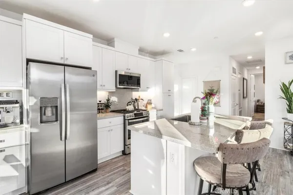 a kitchen with stainless steel appliances granite countertop a stove a sink and a microwave