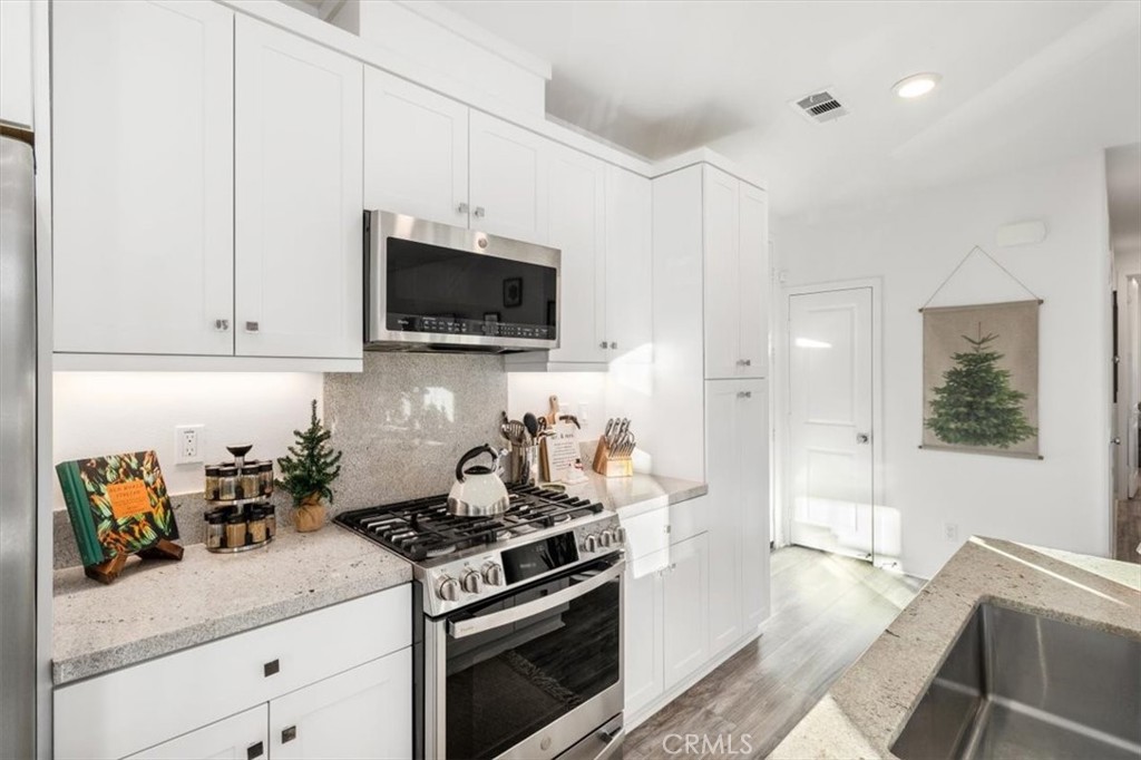 1201 Lasso Way Rancho Mission Viejo, CA 92694 - Photo 13 of 54 a kitchen with stainless steel appliances granite countertop a stove a sink and a microwave