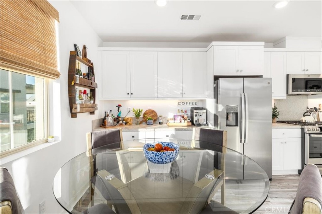 1201 Lasso Way Rancho Mission Viejo, CA 92694 - Photo 17 of 55 a kitchen with stainless steel appliances kitchen island granite countertop a dining table and chairs
