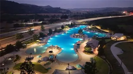 a kitchen with stainless steel appliances granite countertop a stove top oven a sink a dining table and chairs with wooden floor