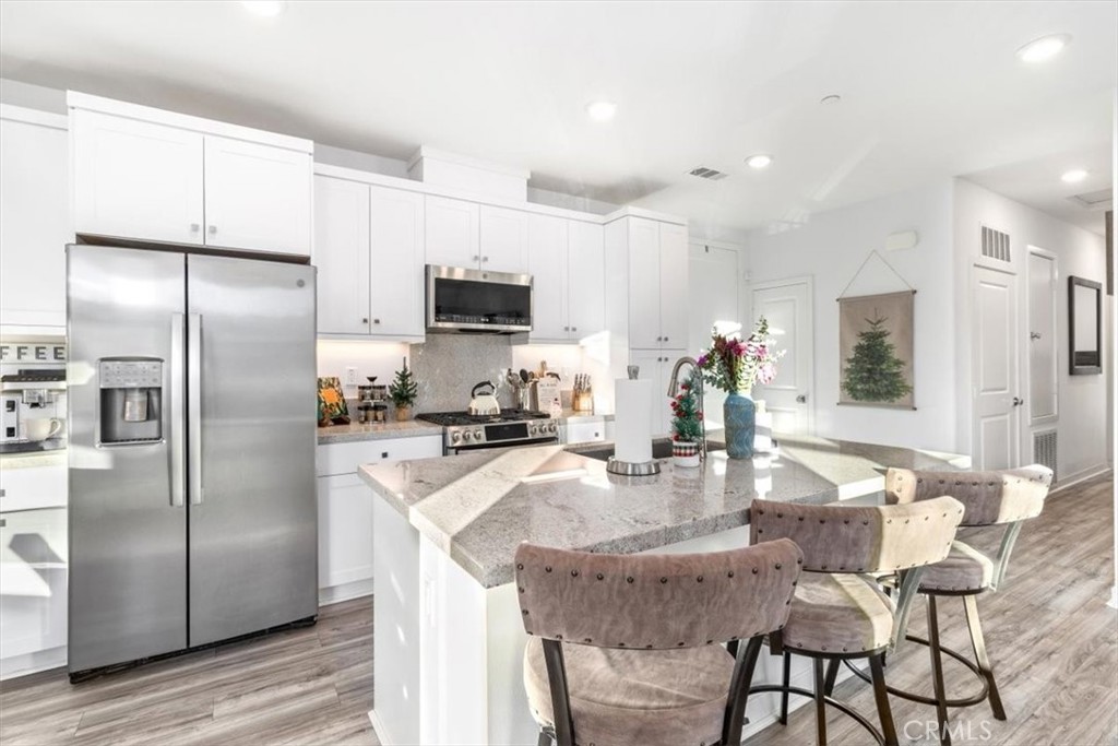 1201 Lasso Way Rancho Mission Viejo, CA 92694 - Photo 10 of 55 a kitchen with kitchen island a refrigerator stove microwave and cabinets