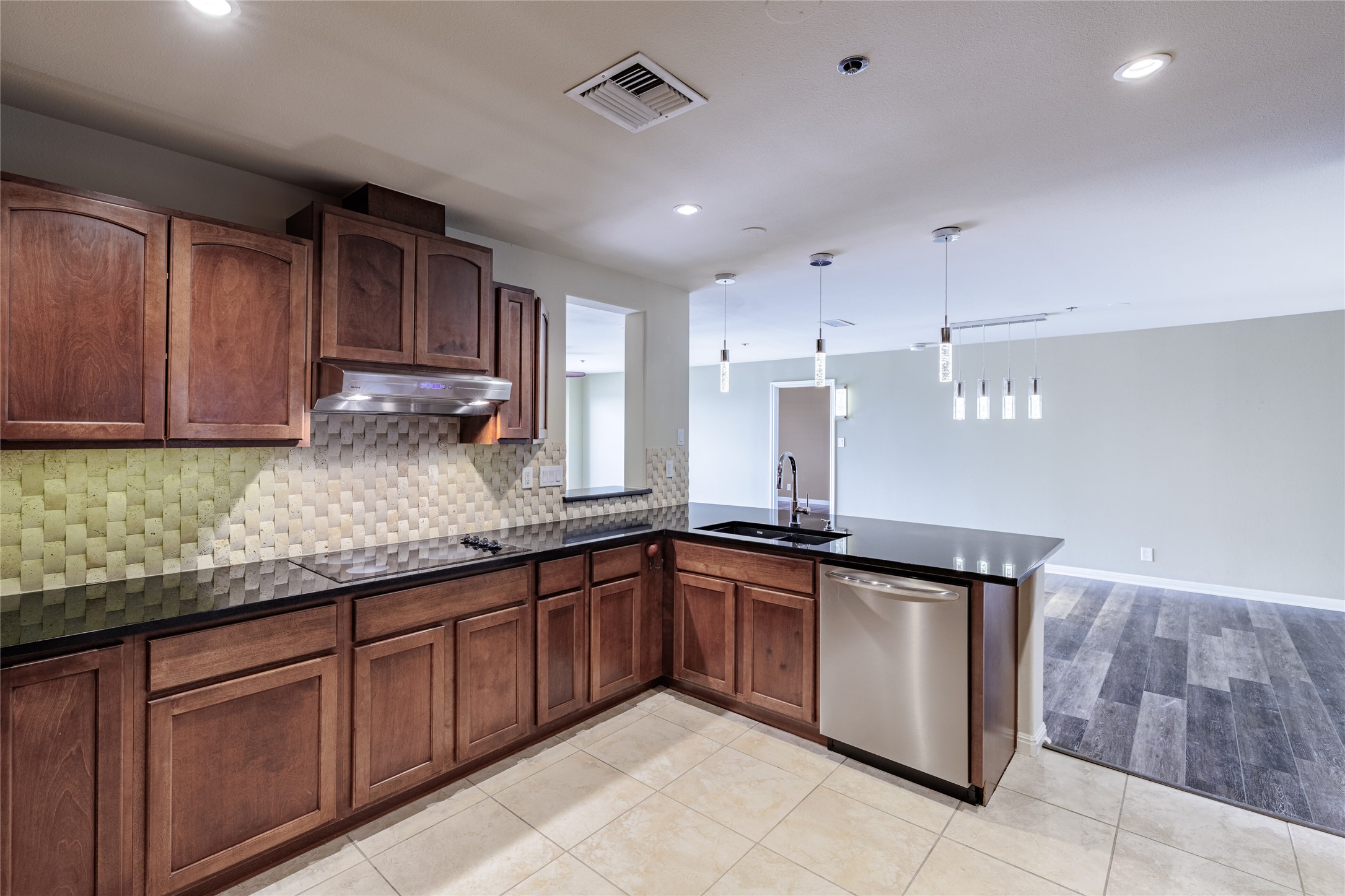 40 North Interstate Highway 35, Unit 6D3 Austin, TX 78701 - Photo 14 of 35 a kitchen with kitchen island granite countertop wooden cabinets a sink and dishwasher