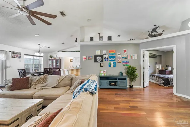 a kitchen with stainless steel appliances granite countertop a stove top oven a dining table and chairs with wooden floor