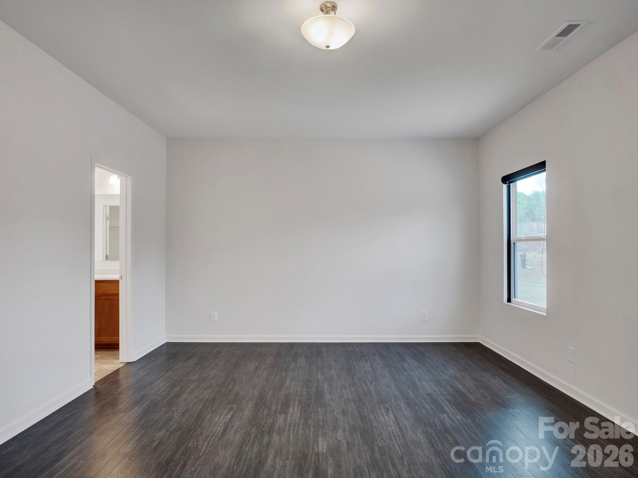 4327 Bent Green Lane Monroe, NC 28112 - Photo 16 of 28 an empty room with wooden floor and windows