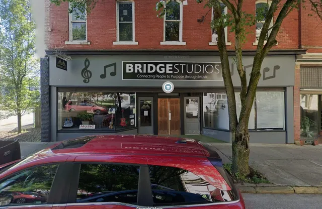 a front view of multi story building with retail shop and outdoor seating