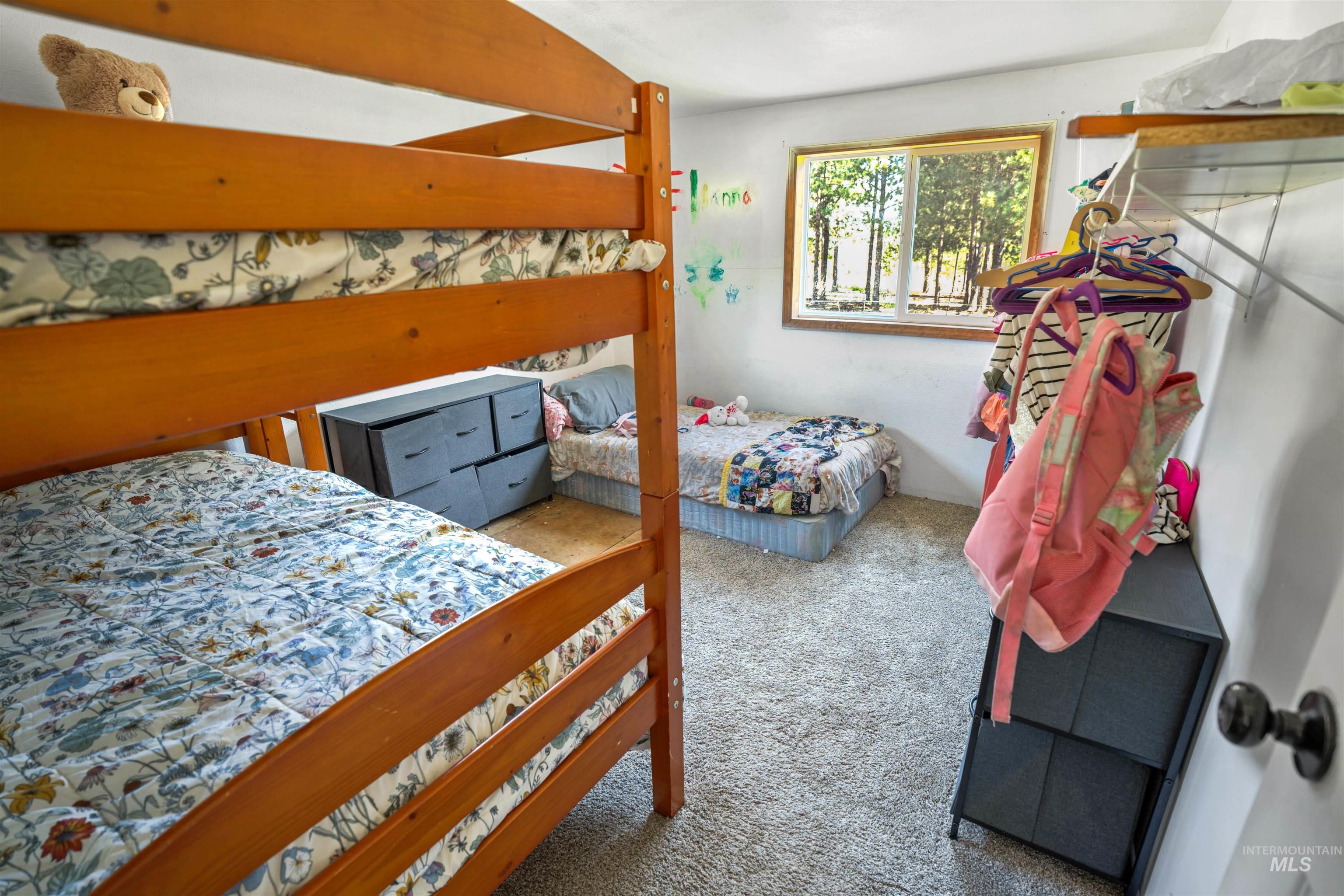 1910 East Mountain Road Anatone, WA 99401 - Photo 14 of 41 Carpeted room with a wooden-frame bunk bed and a single window offering a wooded outdoor scene