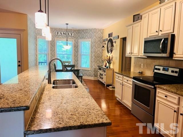 70 Breadnut Drive Smithfield, NC 27577 - Photo 17 of 19 a kitchen with stainless steel appliances granite countertop a sink stove and refrigerator