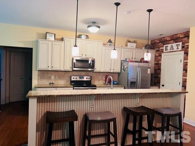 70 Breadnut Drive Smithfield, NC 27577 - Photo 18 of 19 a kitchen with stainless steel appliances granite countertop a stove a sink refrigerator and microwave