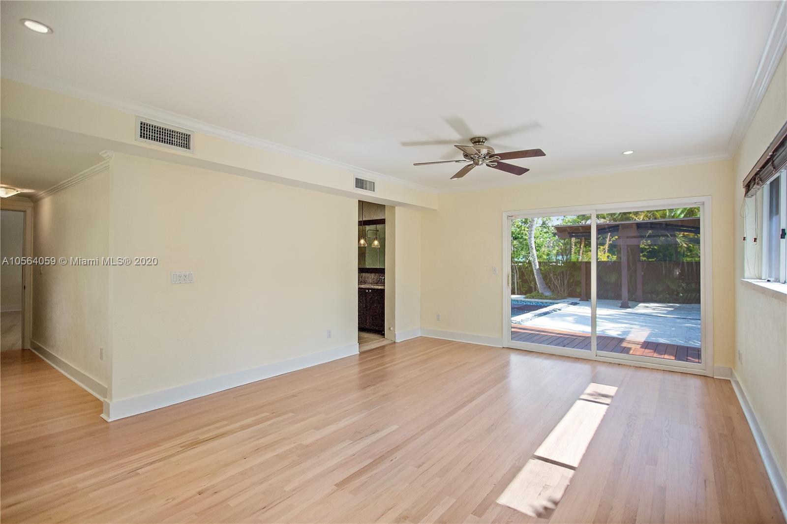 335 Pacific Road Key Biscayne, FL 33149 - Photo 19 of 50 a view of a livingroom with wooden floor and a ceiling fan