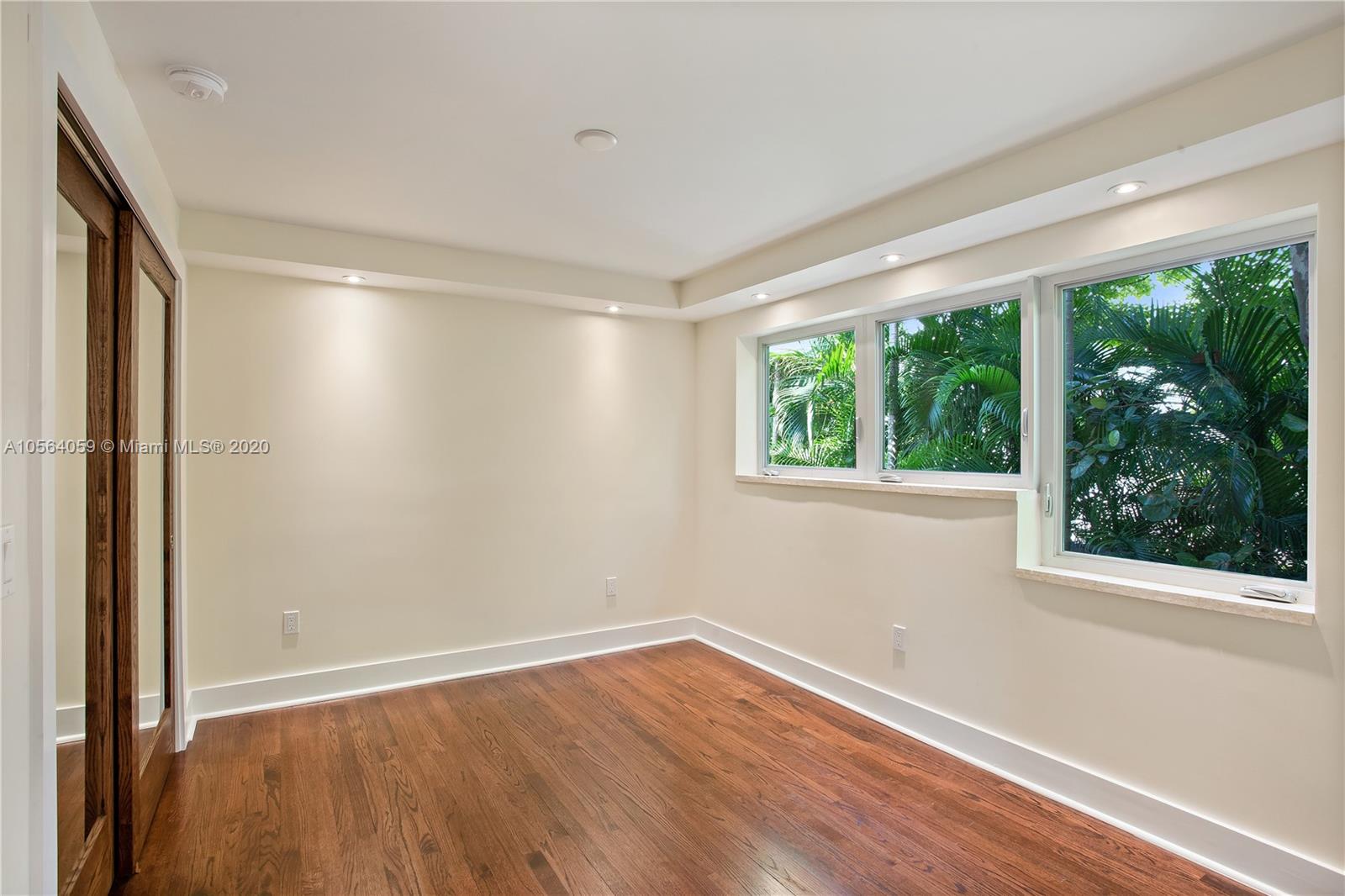 335 Pacific Road Key Biscayne, FL 33149 - Photo 23 of 50 an empty room with wooden floor and windows