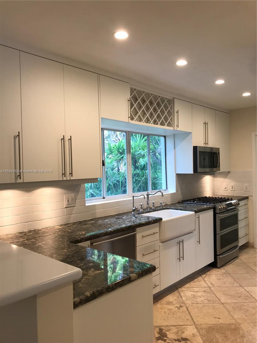 335 Pacific Road Key Biscayne, FL 33149 - Photo 29 of 50 a kitchen with stainless steel appliances granite countertop a sink a stove and a refrigerator