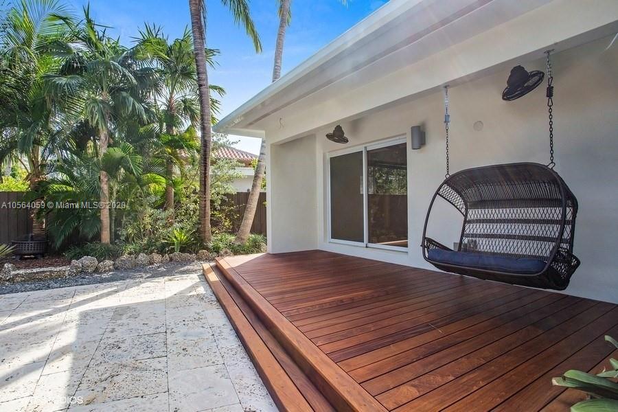 335 Pacific Road Key Biscayne, FL 33149 - Photo 35 of 50 a wooden bench sitting in front of a building