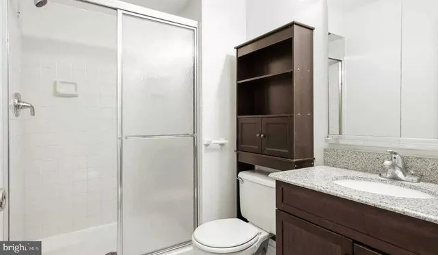 a bathroom with a granite countertop sink toilet and shower