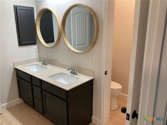 a bathroom with a toilet sink and mirror