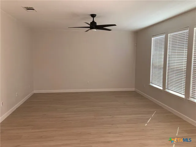 a view of a room with a window and a ceiling fan