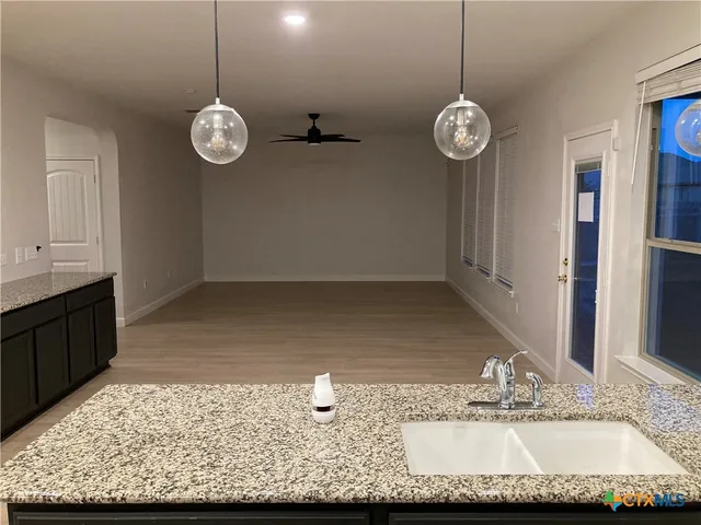 a view of a kitchen with a refrigerator cabinets and wooden floor