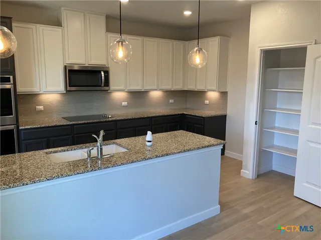 a kitchen with kitchen island a counter space a sink and appliances
