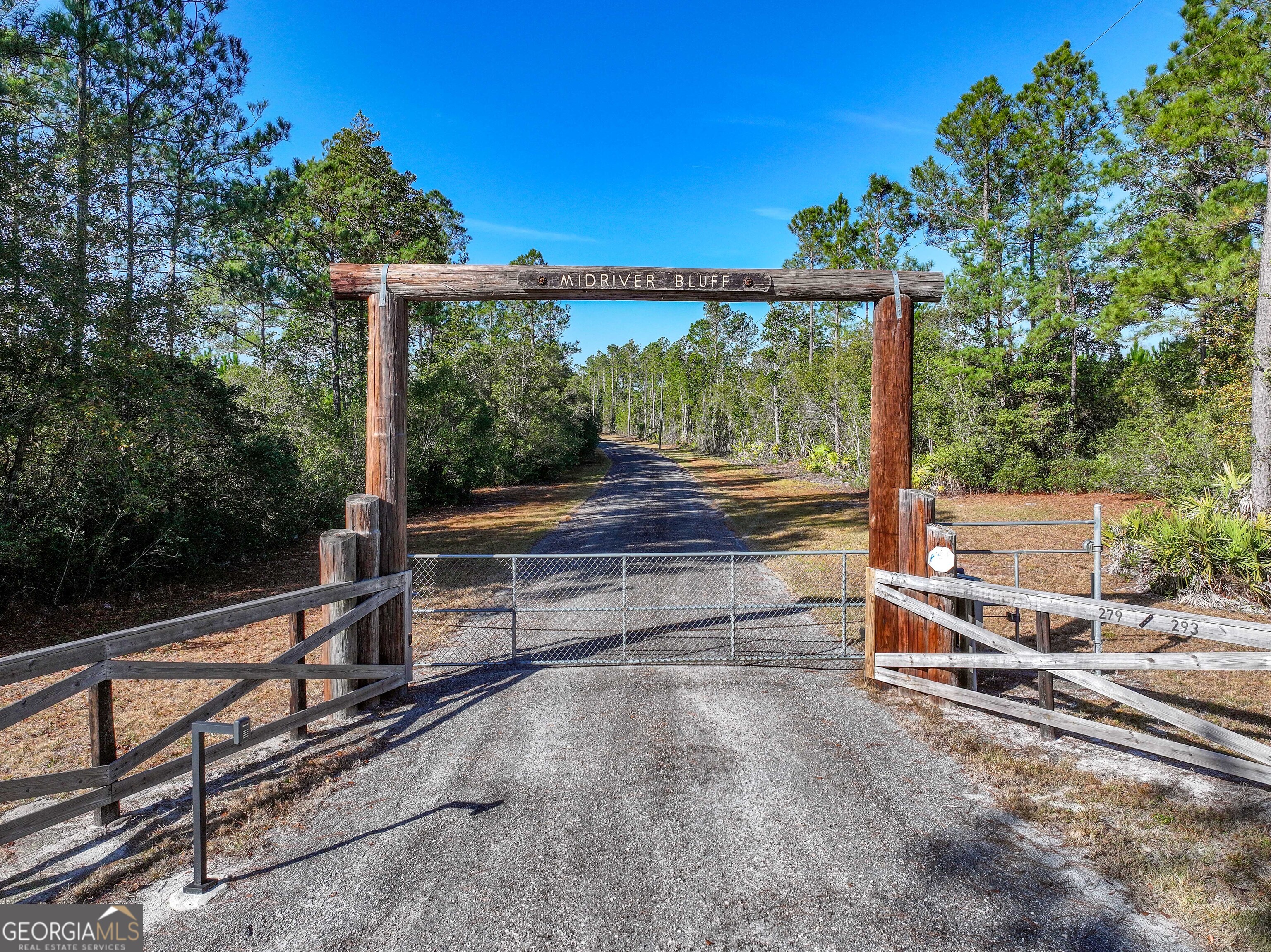 a sitting area with large trees in front of it
