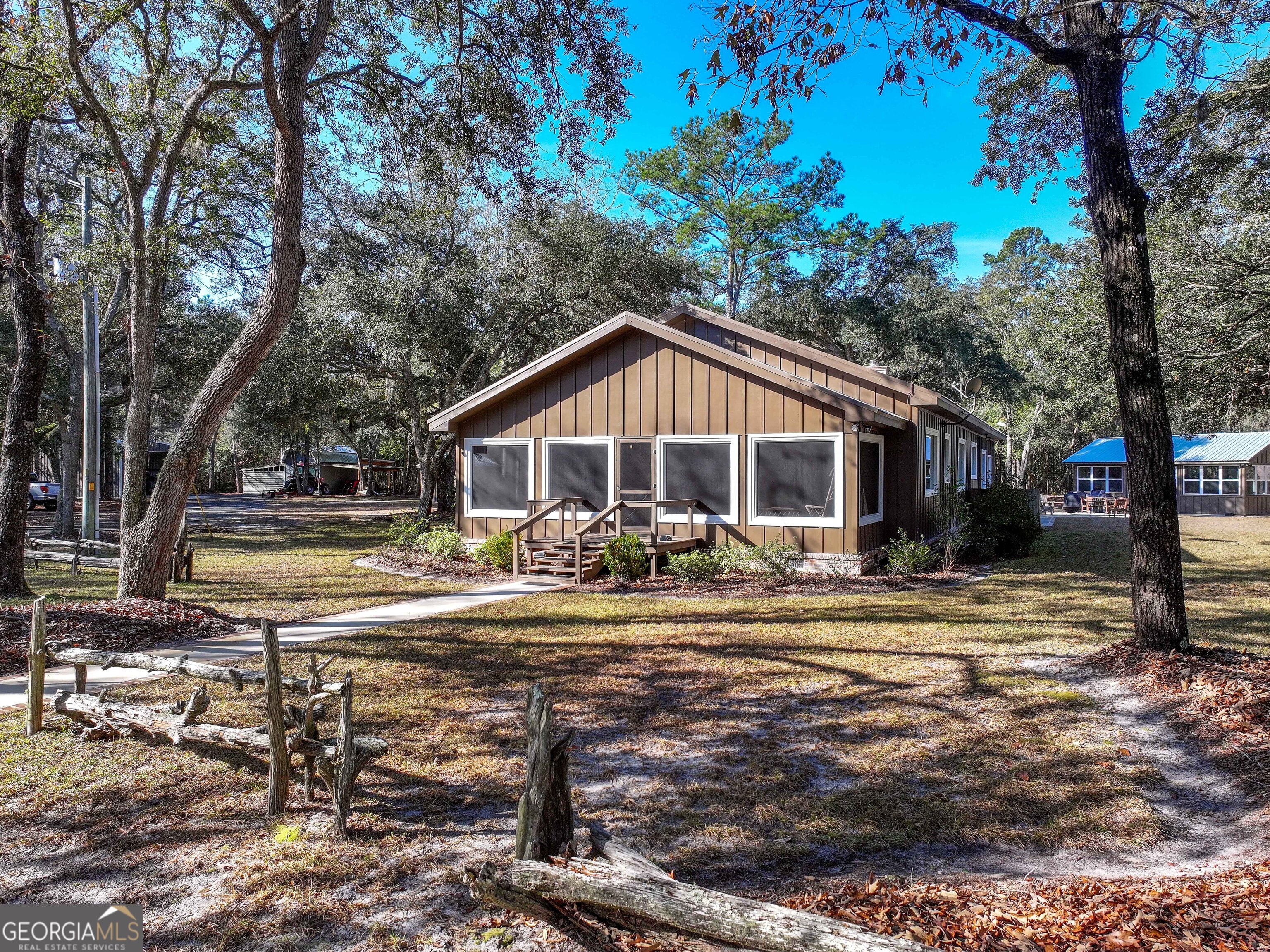 279 Mid River Road White Oak, GA 31568 - Photo 4 of 62 a front view of a house with swimming pool having outdoor seating