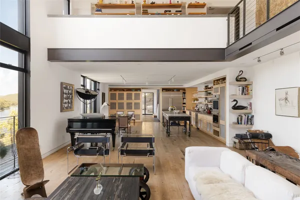 a living room with furniture kitchen view and large windows
