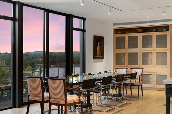 a kitchen with stainless steel appliances a dining table and chairs in it