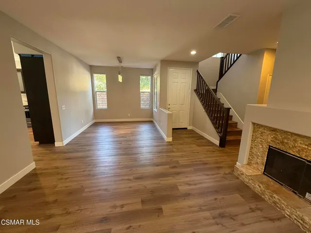 a view of a livingroom with wooden floor and a fireplace