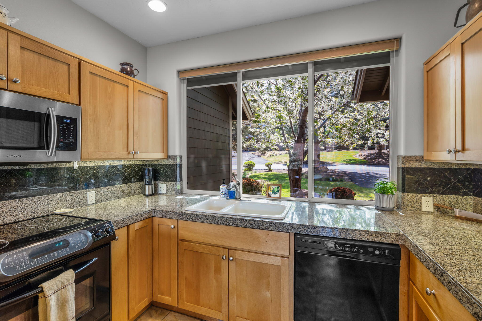 10870 Village Loop Redmond, OR 97756 - Photo 6 of 35 a kitchen with stainless steel appliances granite countertop a sink a stove and a microwave