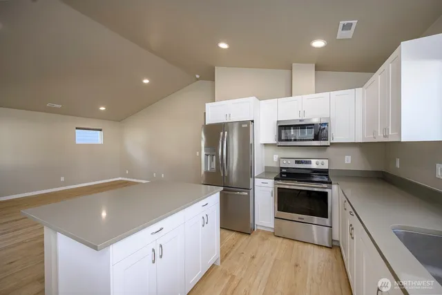 a kitchen with a refrigerator and white cabinets